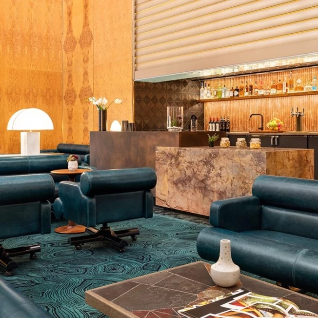 A hotel lobby lounge with a bar, seating area, and decorative elements.