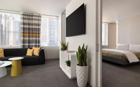 A wide view of a hotel suite with a living area and bedroom.