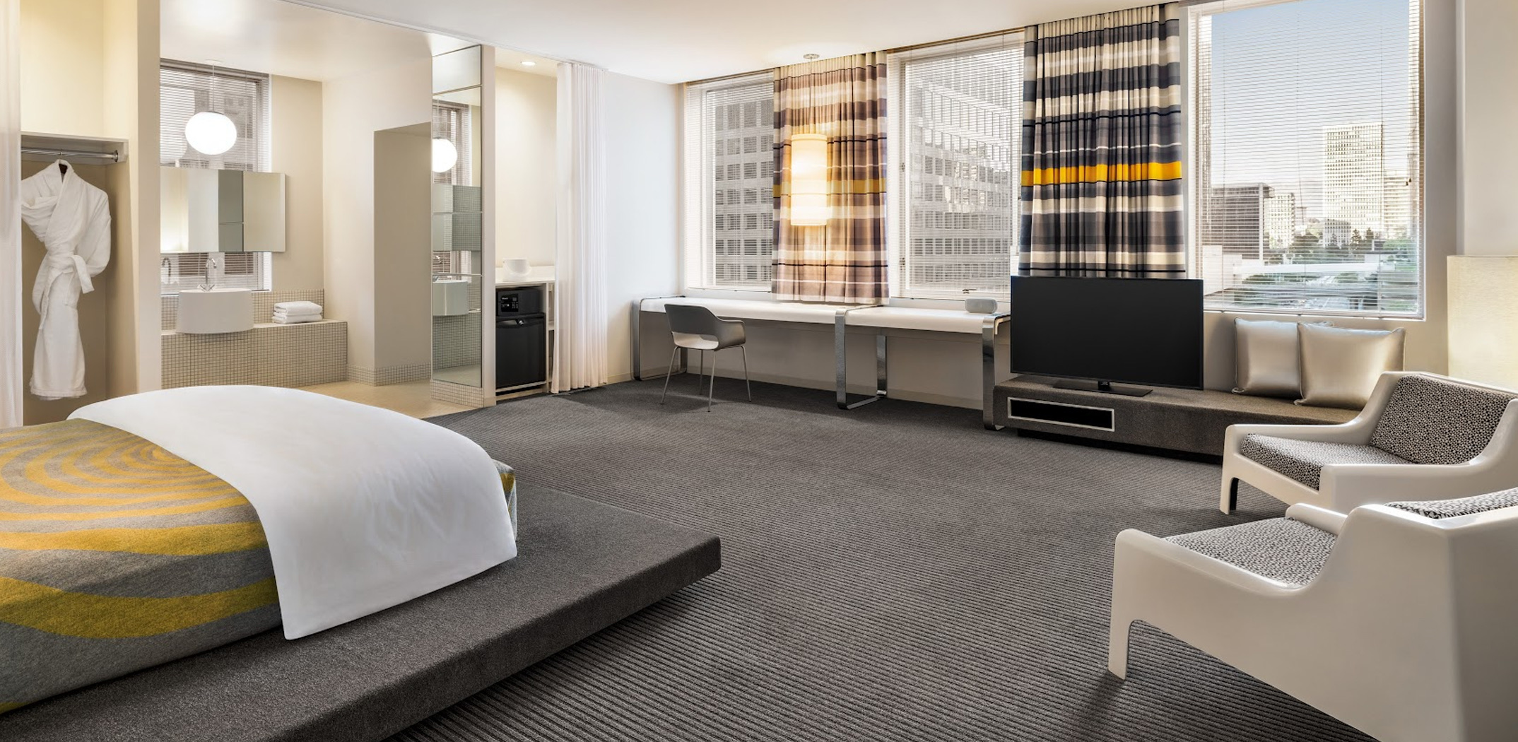 a room with a bed and chairs