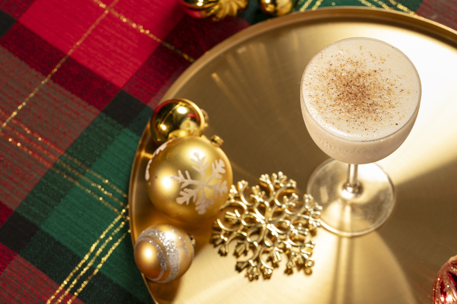 a glass of drink on a gold tray