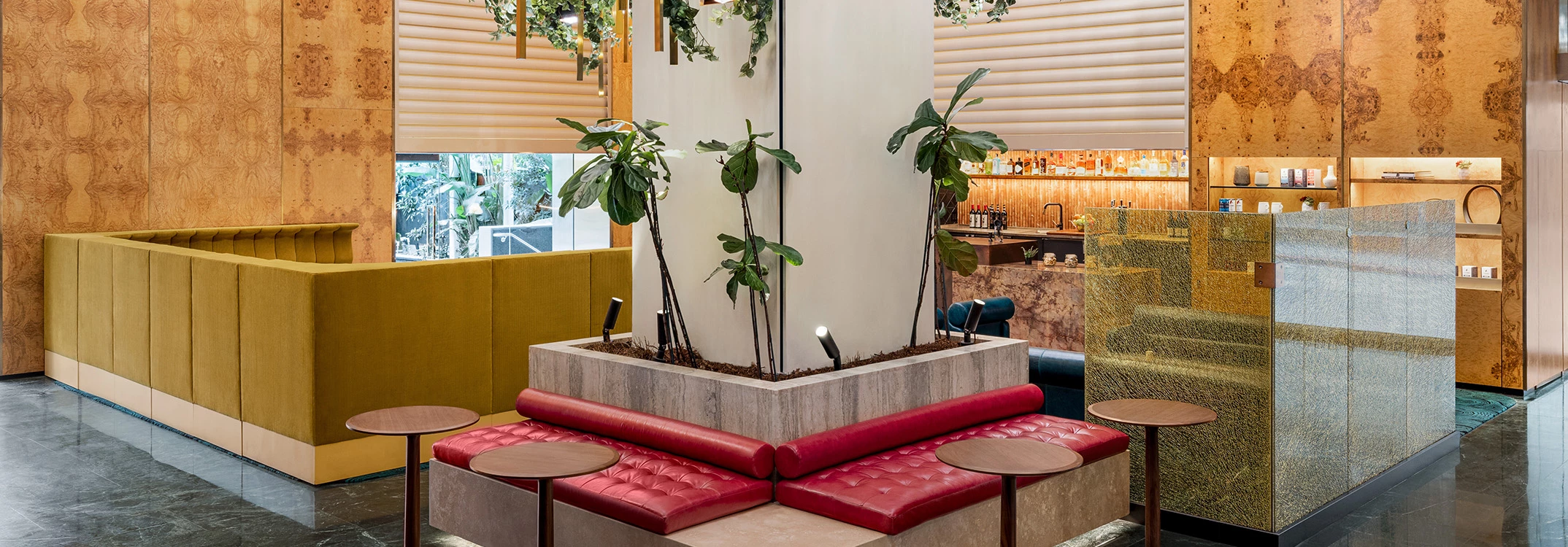 A lobby with a red bench, plants, and a yellow divider.
