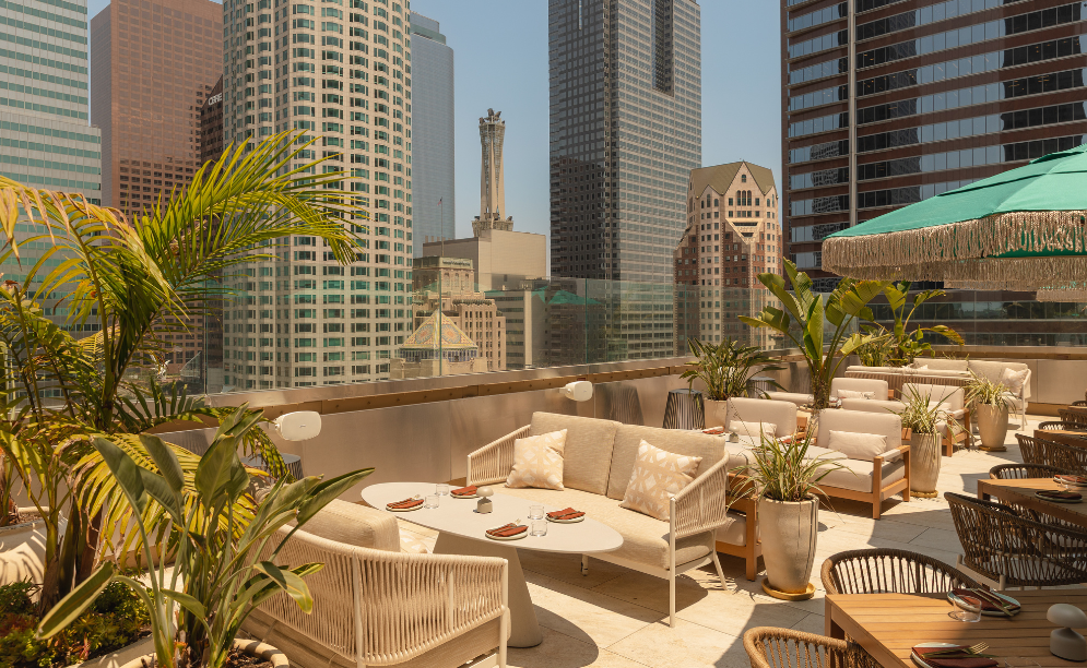 a rooftop patio with a view of skyscrapers and a city