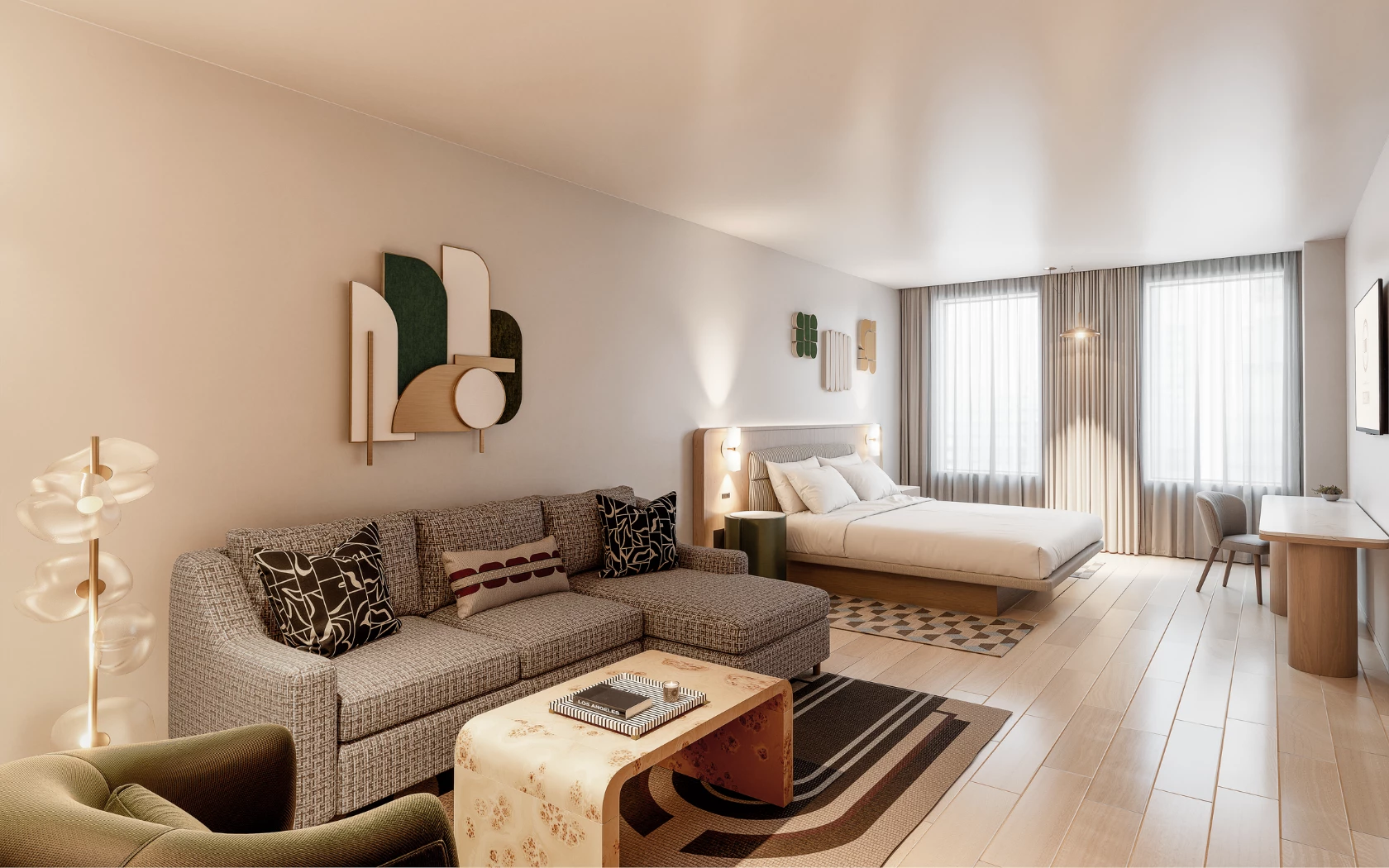 A wide view of a hotel room with a sofa, coffee table, bed, desk, and window.
