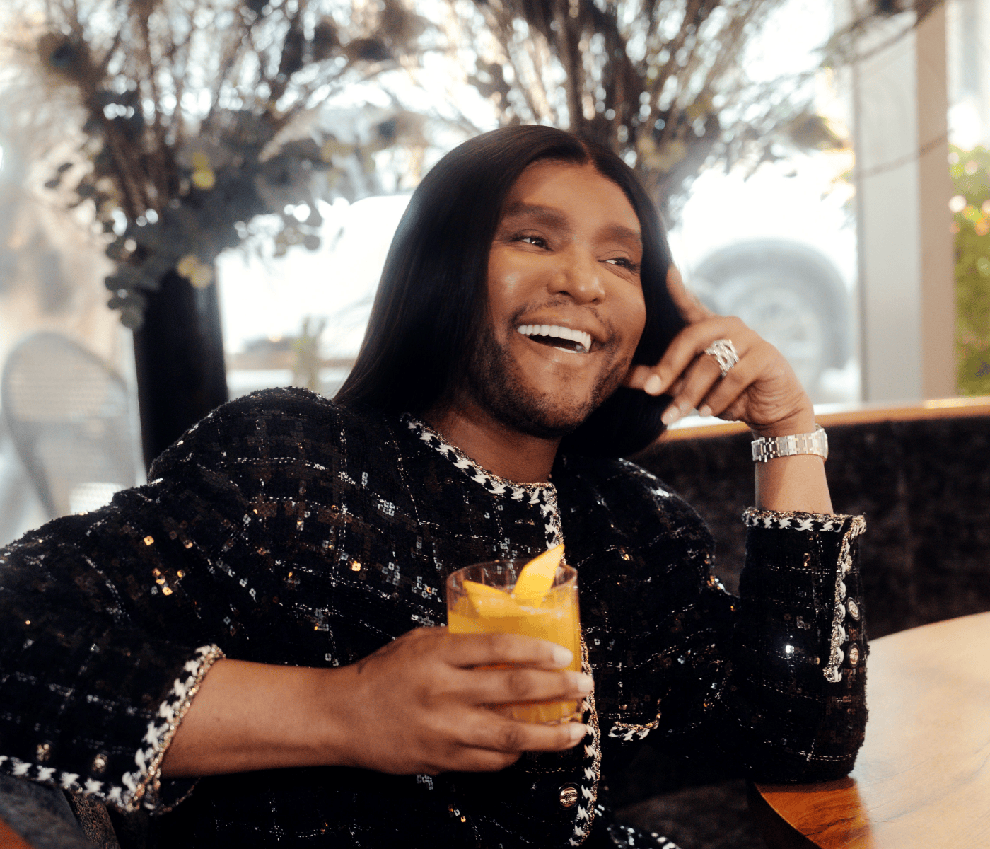 a man holding a drink and smiling