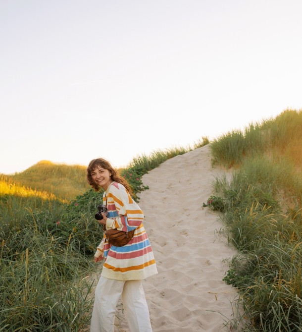 a woman walking on a path with grass