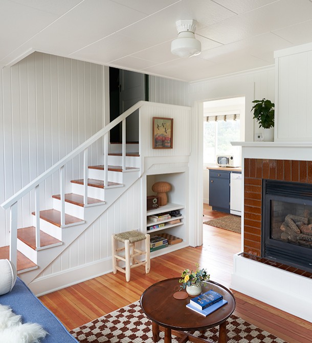 The living room with a staircase leading to another room.