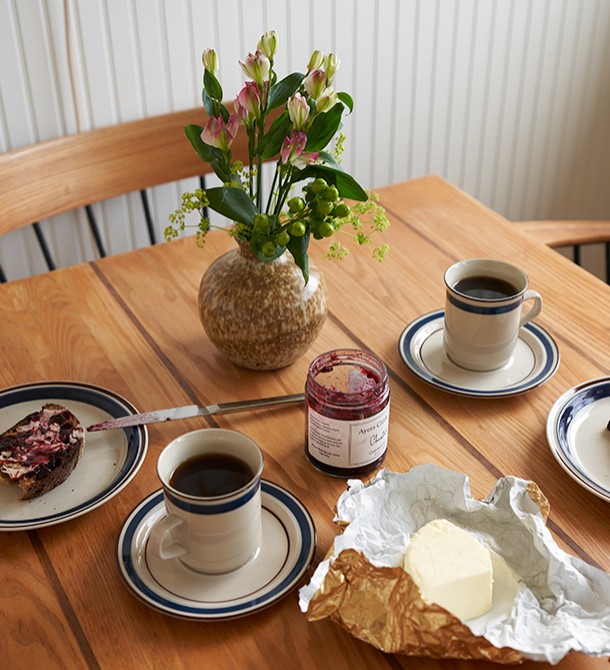 A close up of a wooden table with jellied toast and coffee.