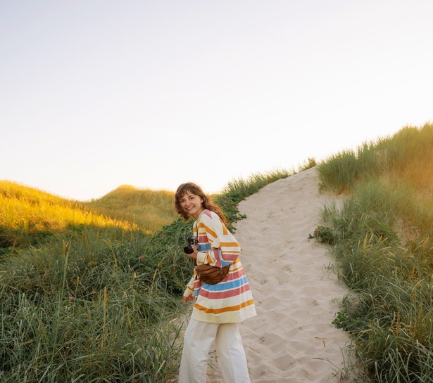 a woman standing on a path with a camera