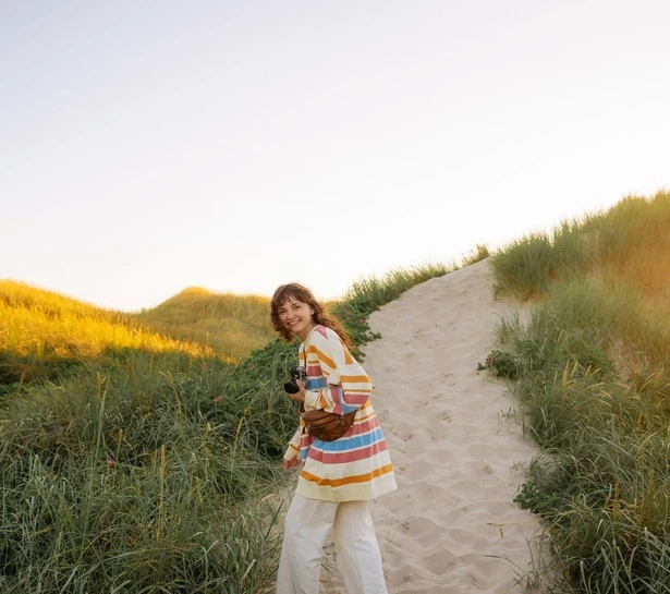 a woman standing on a path with a camera