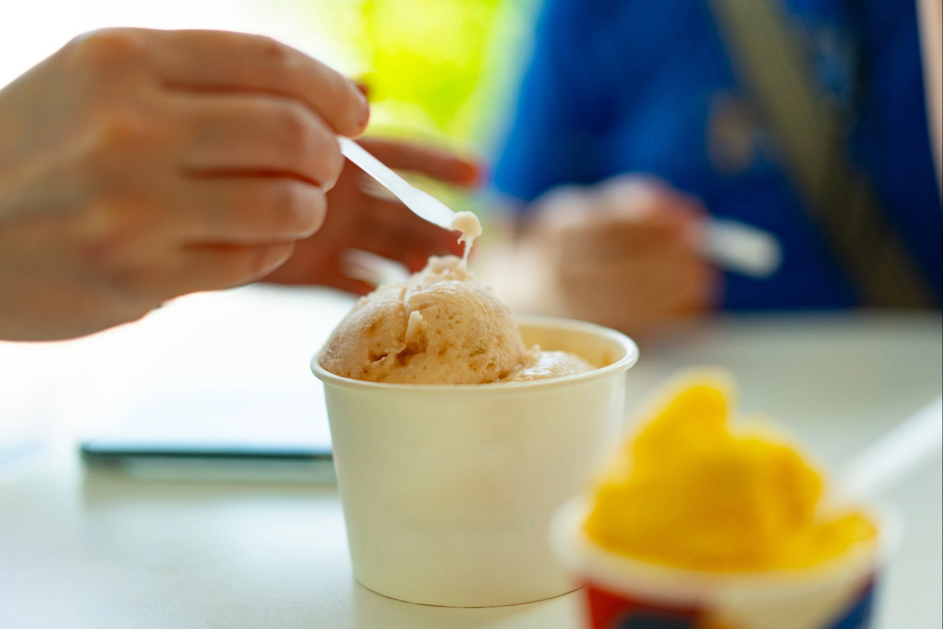 a person putting a spoon into a cup of ice cream