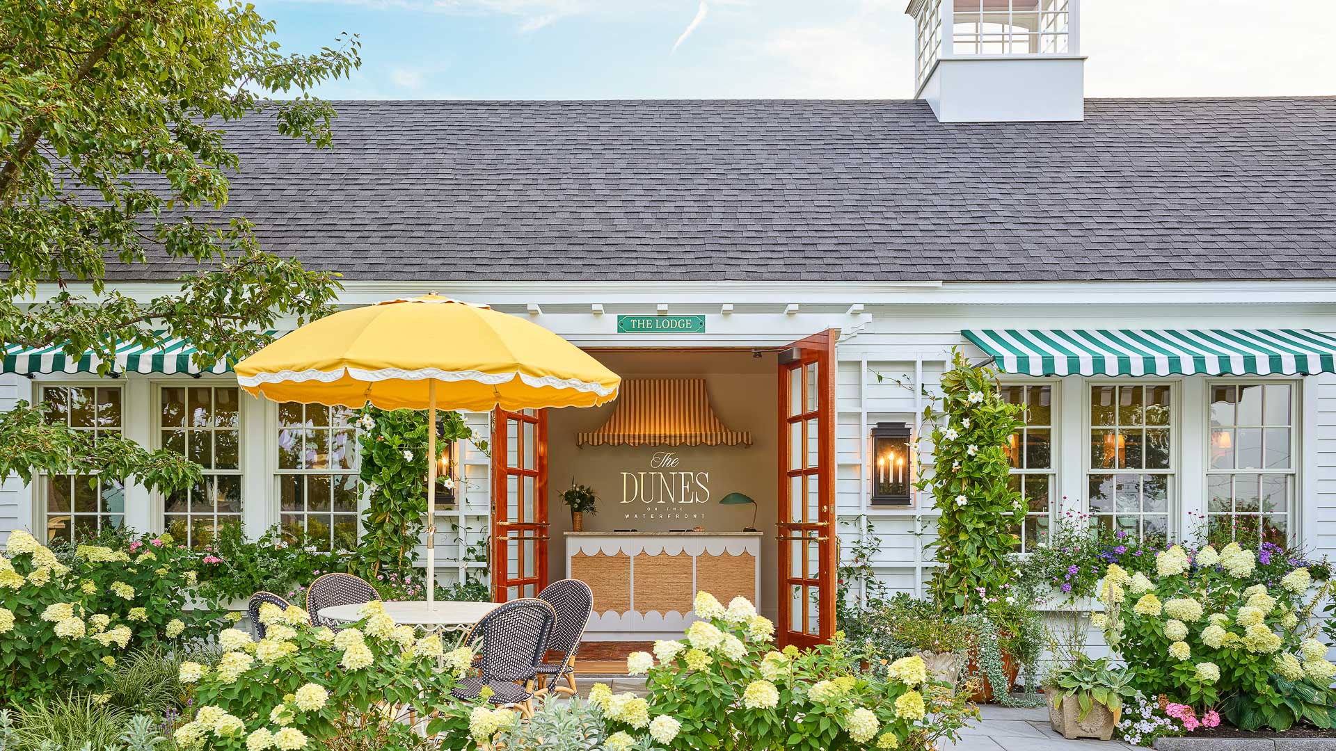 a white building with yellow umbrellas and chairs