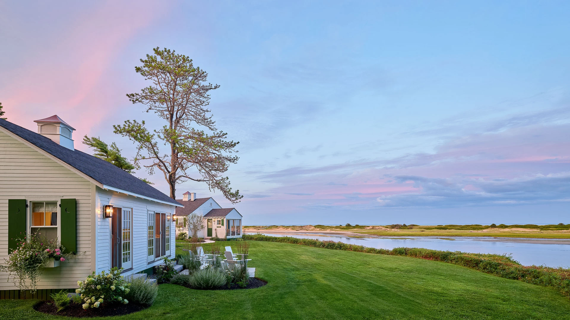 a house with a lawn and a body of water