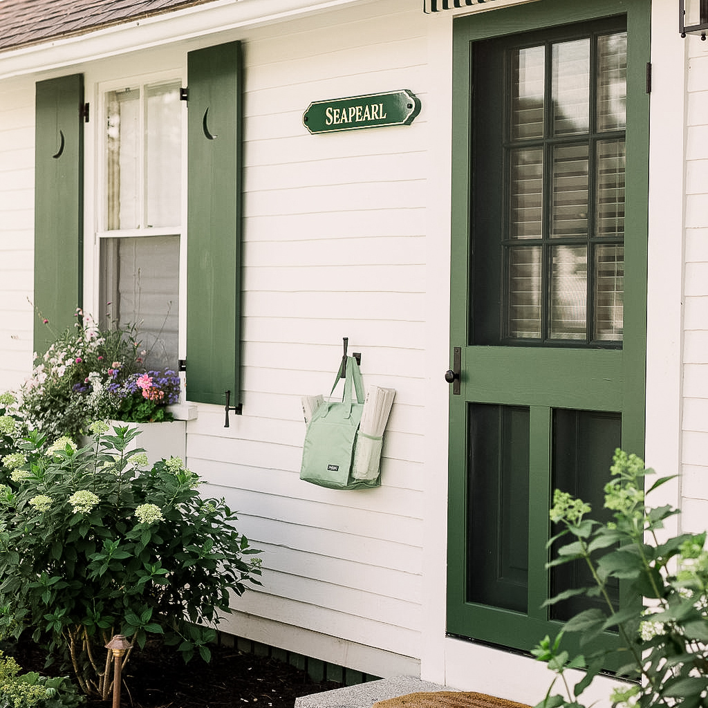 a green door and window with a sign on the side of a house