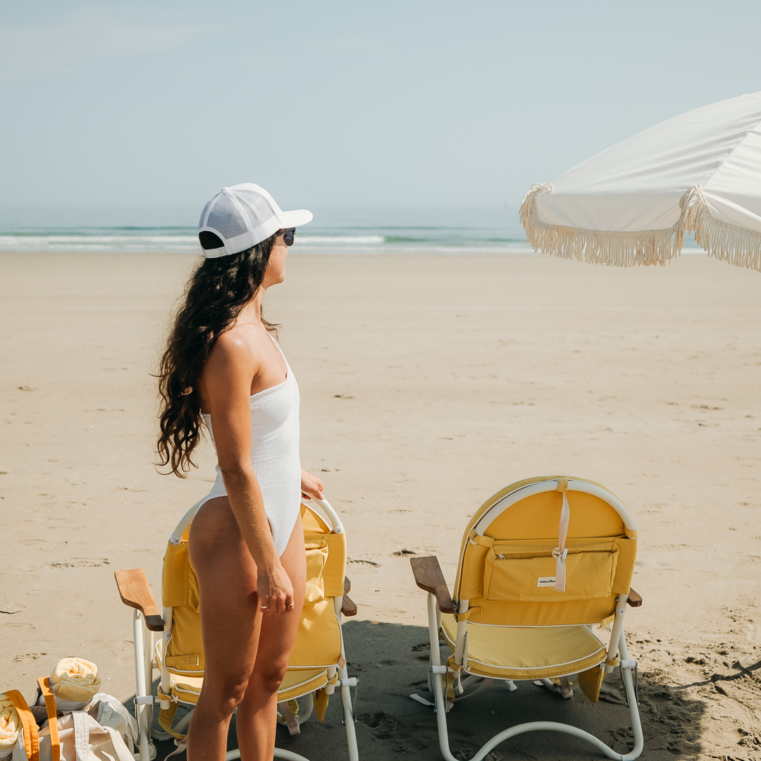 a woman standing in a white bathing suit on a beach