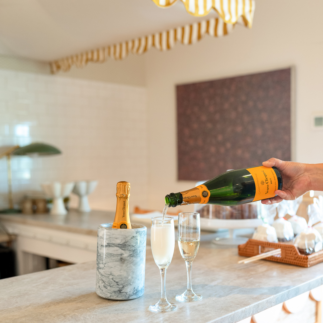 a person pouring champagne into two glasses