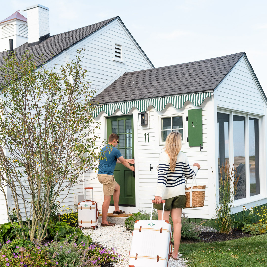 a man and woman with luggage outside a house