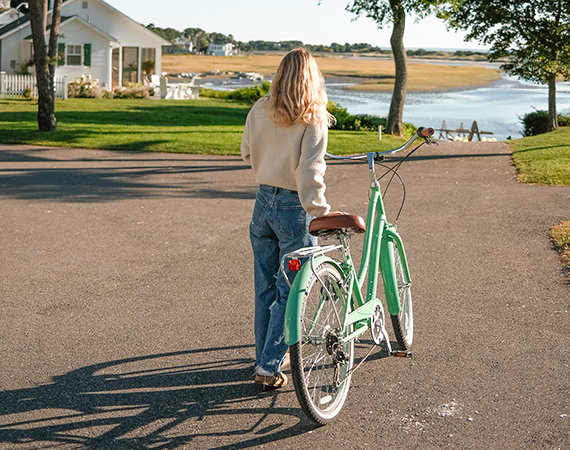 a woman walking with a bicycle