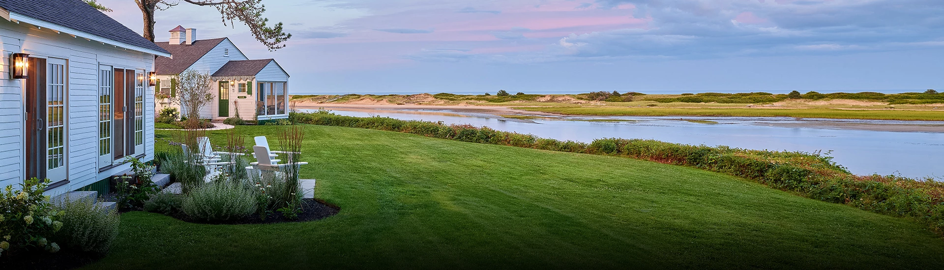 a golf course with a body of water and a blue sky