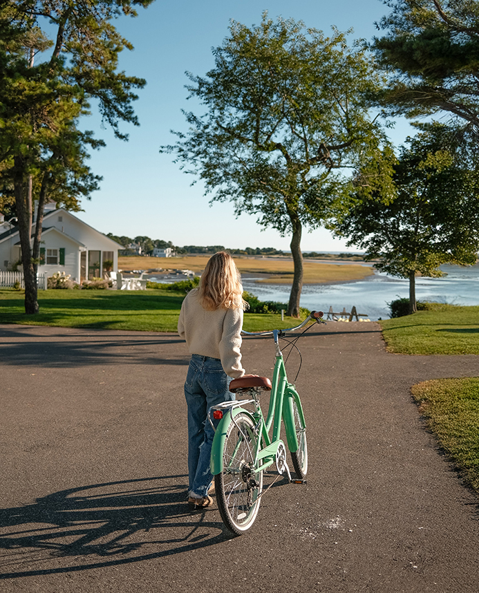 a woman walking with a bicycle on a path