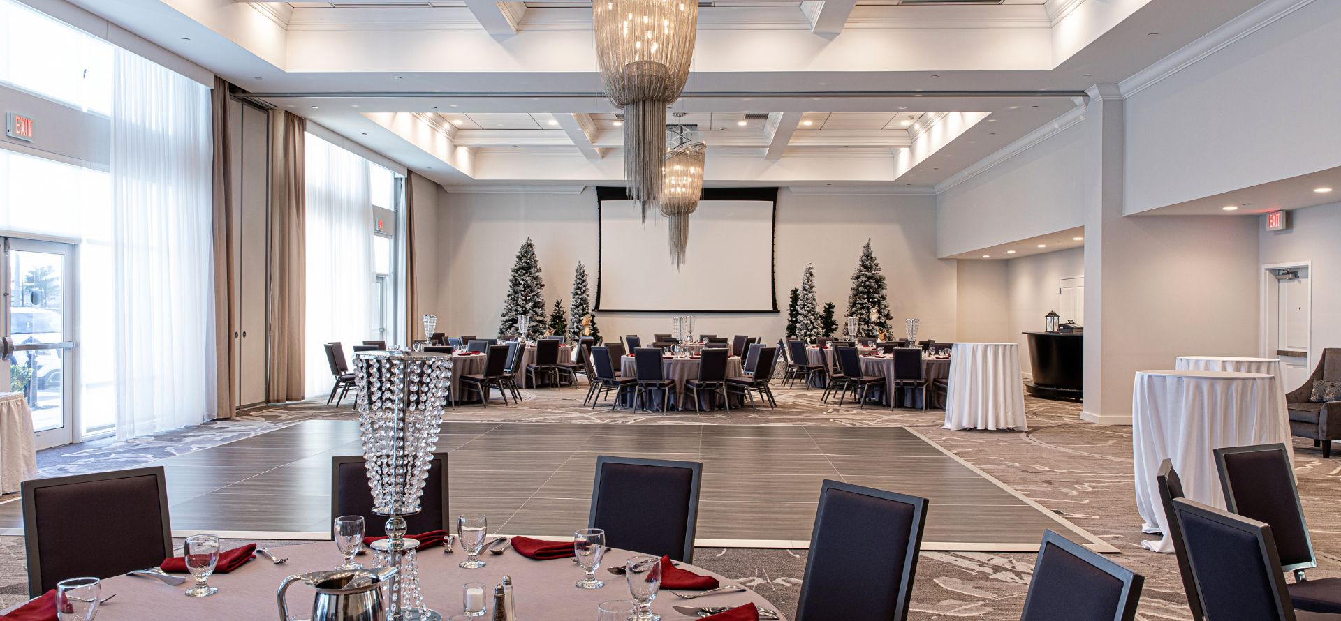 a room with tables and chairs and a projector screen