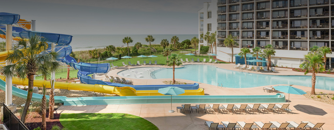 a pool with water slides and chairs