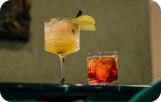 a glass of liquid with fruit on top of it