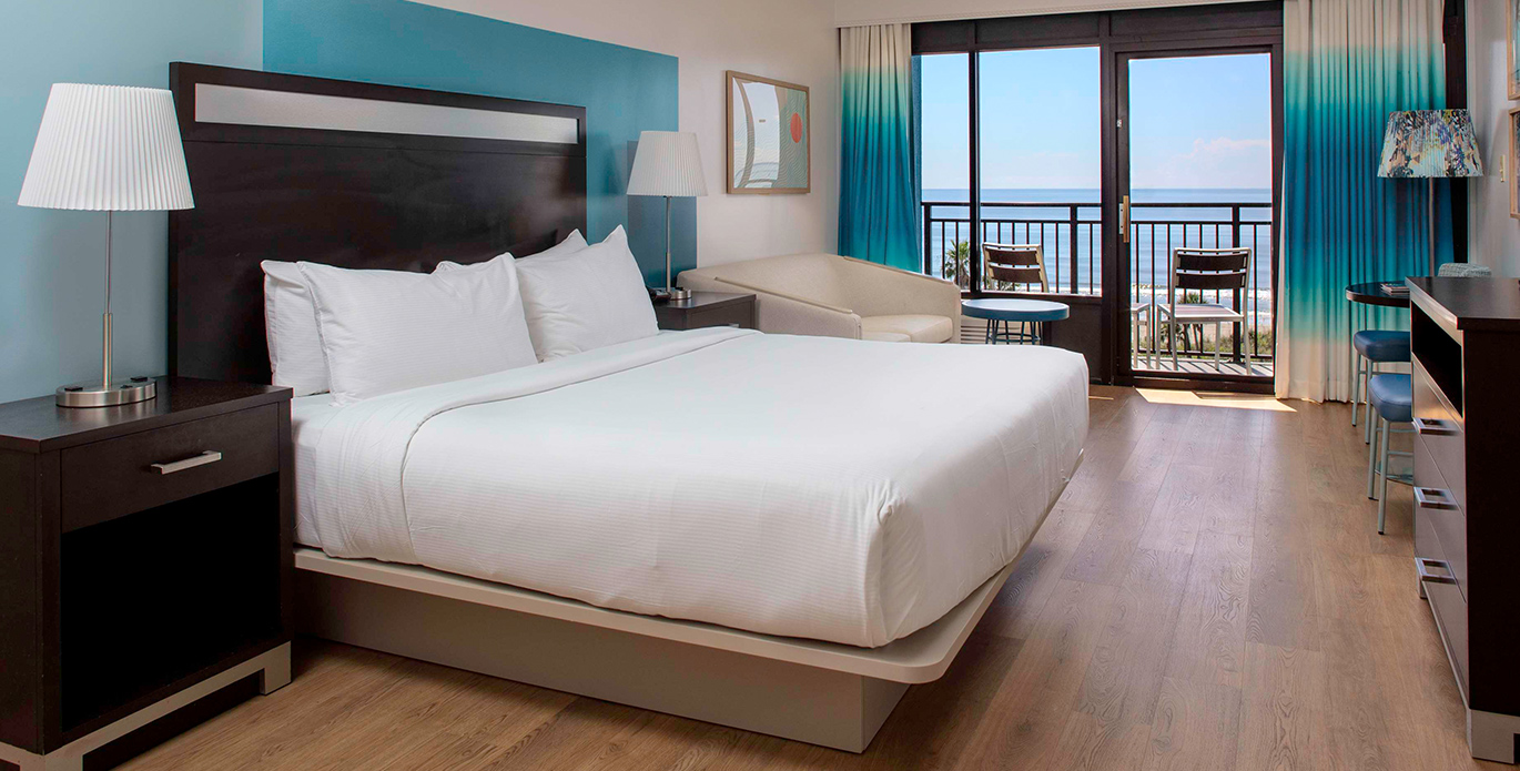 a woman sitting on a bed holding a cup