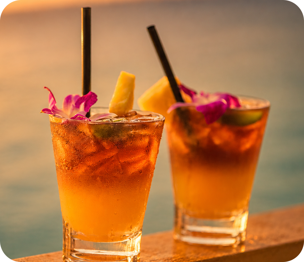 two glasses of liquid with straws and flowers
