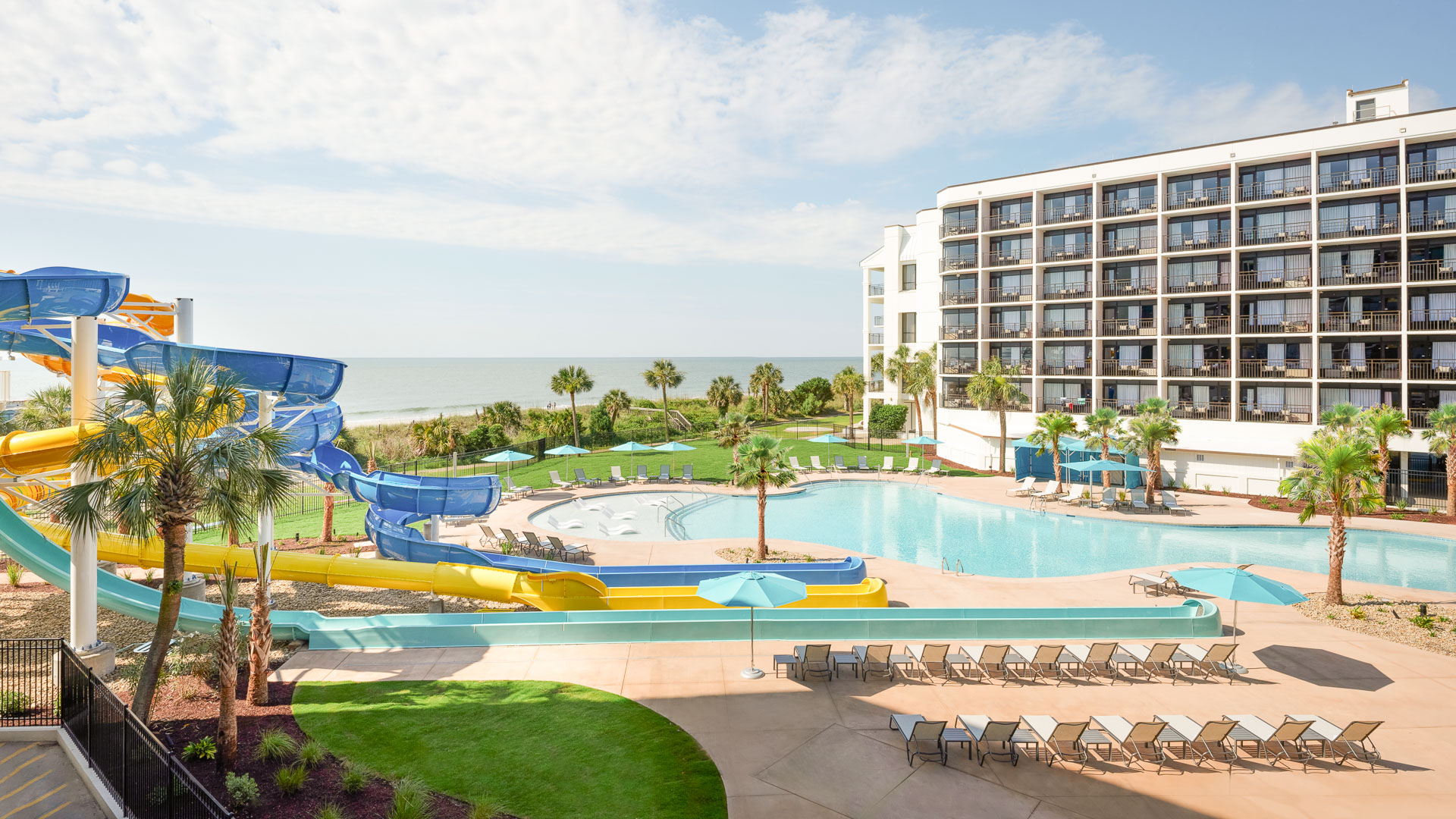 a pool with a slide and chairs
