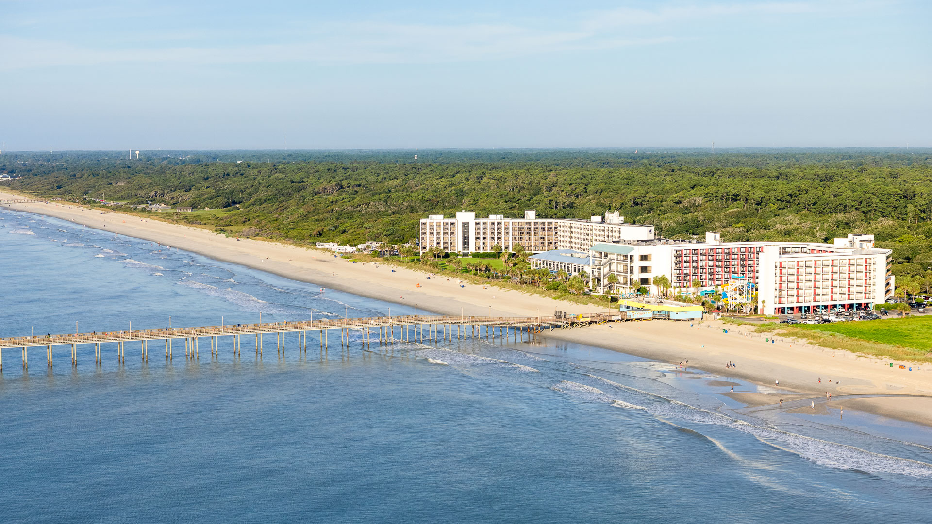 a beach with a pier and buildings