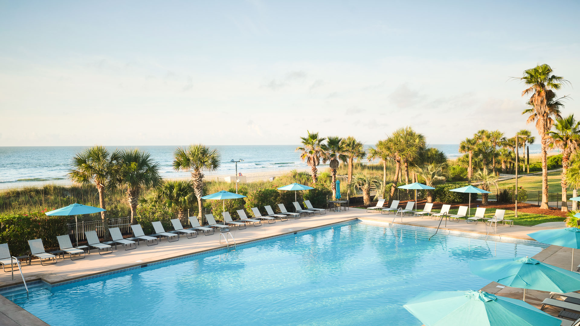 a pool with lounge chairs and umbrellas