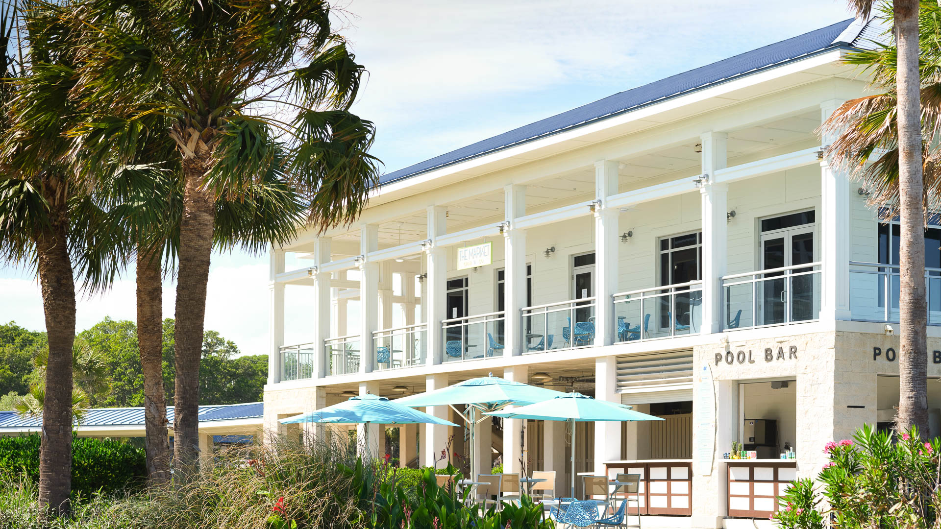 a building with a palm tree and umbrellas