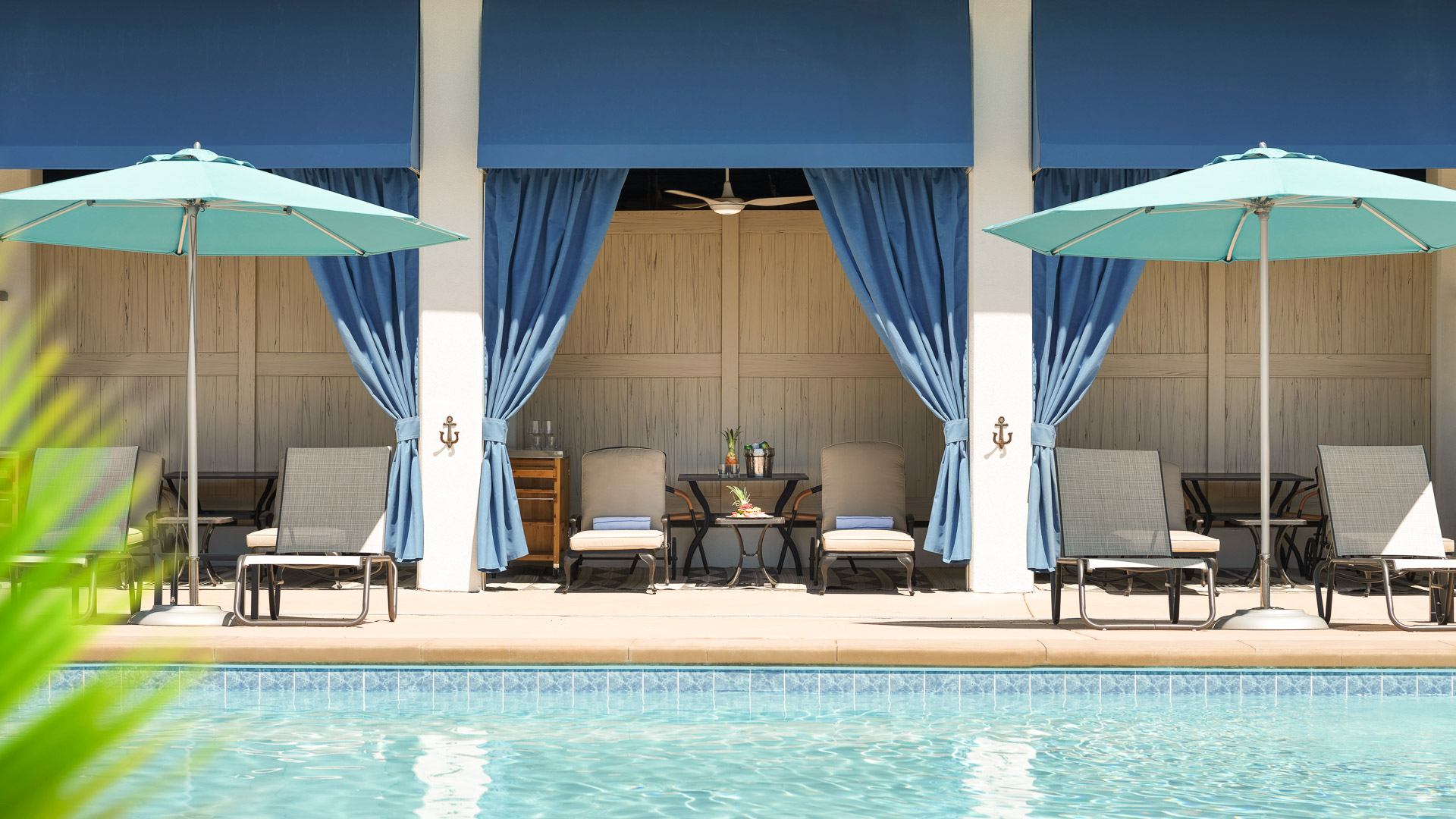 a pool with blue curtains and chairs with Walt Disney Concert Hall in the background