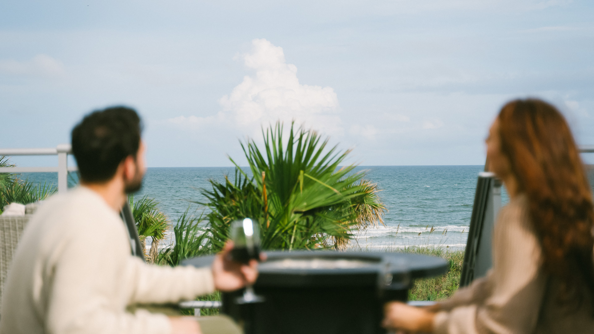 a man and woman sitting at a table with a glass of wine