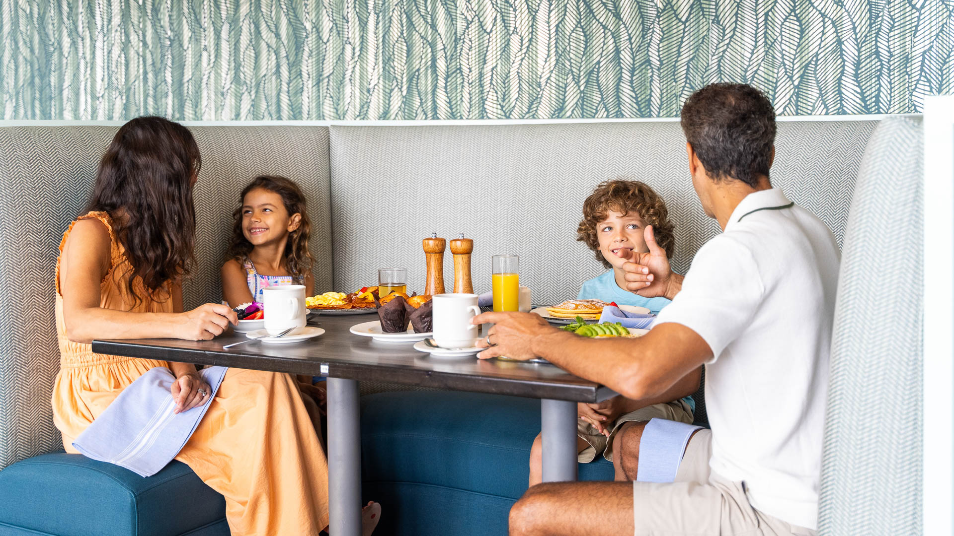 a group of people sitting at a table with food