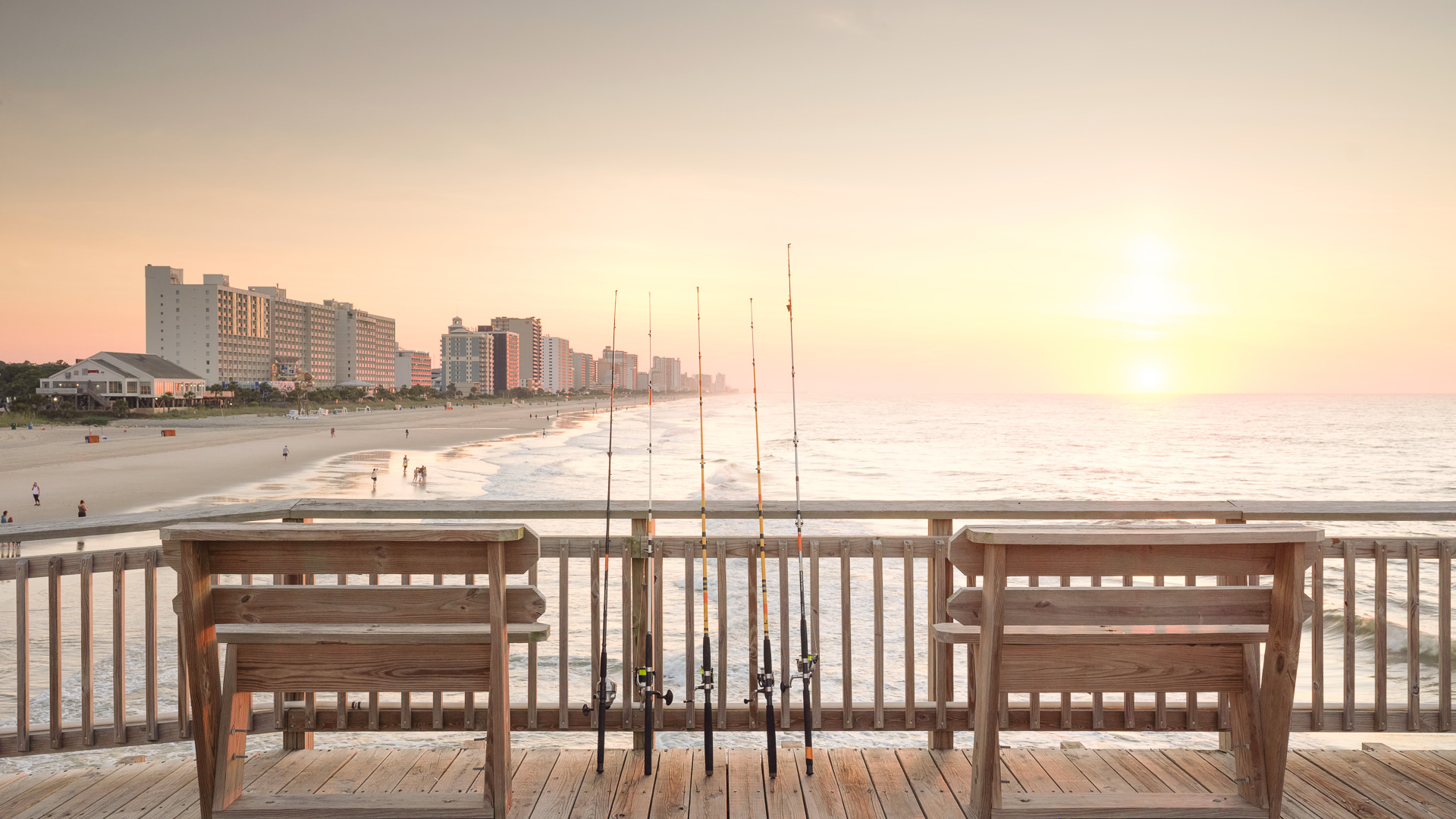 a group of fishing poles on a deck overlooking a beach