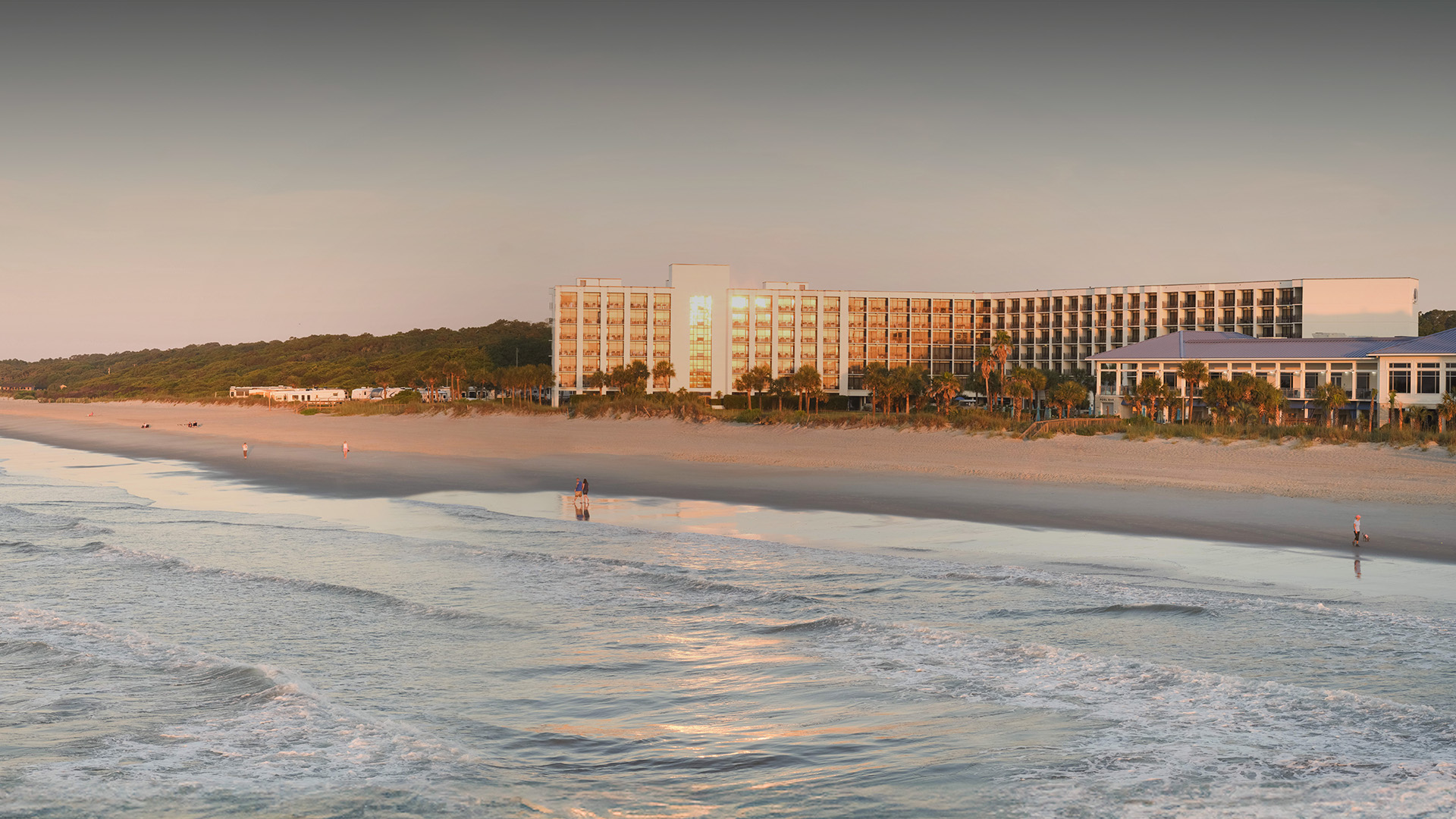 a beach with a building and trees