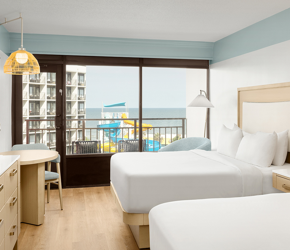 a room with two beds and a table and chairs