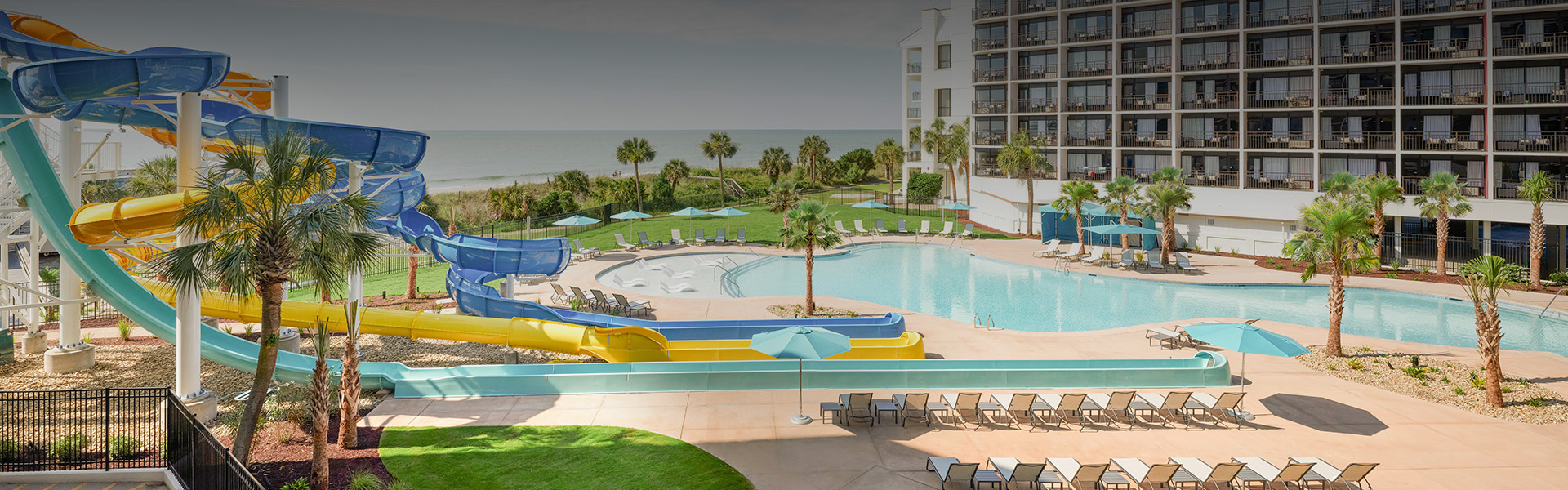 a pool with a slide and chairs