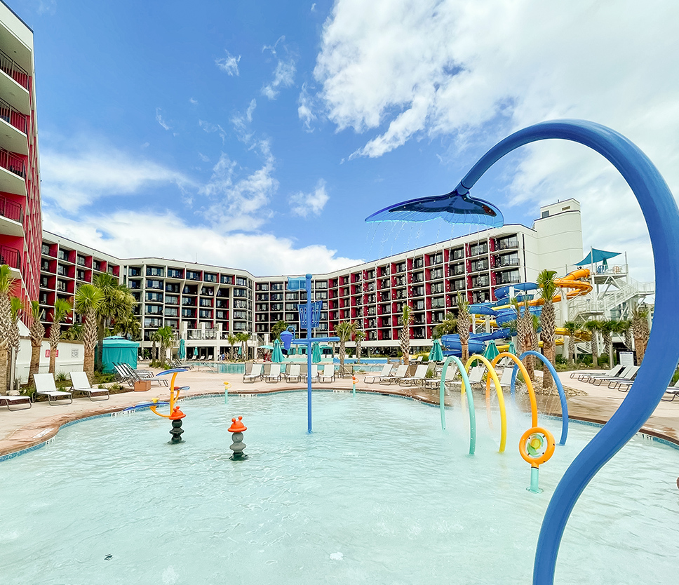 a pool with water slides and a building in the background