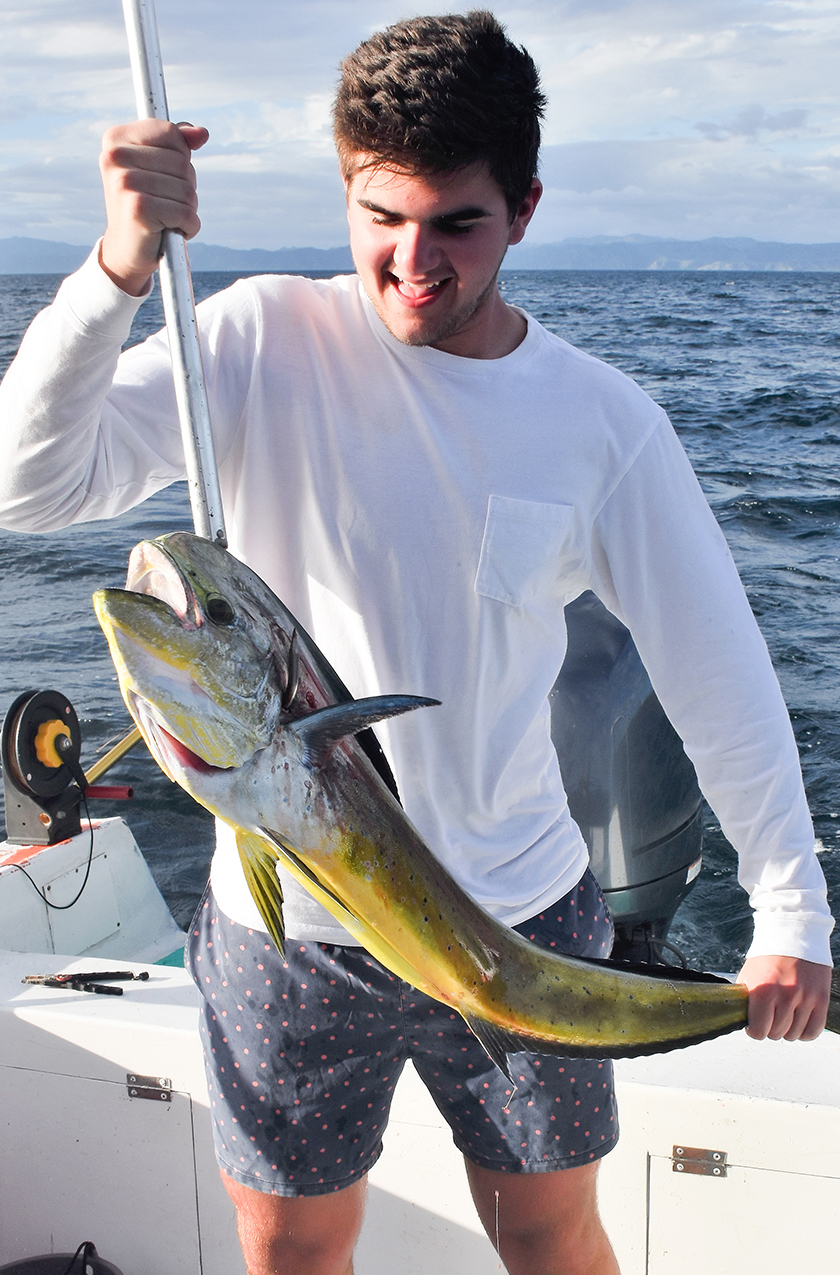 a man holding a fish on a boat