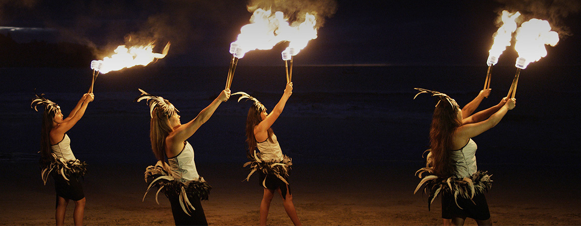 two women holding torches with flames
