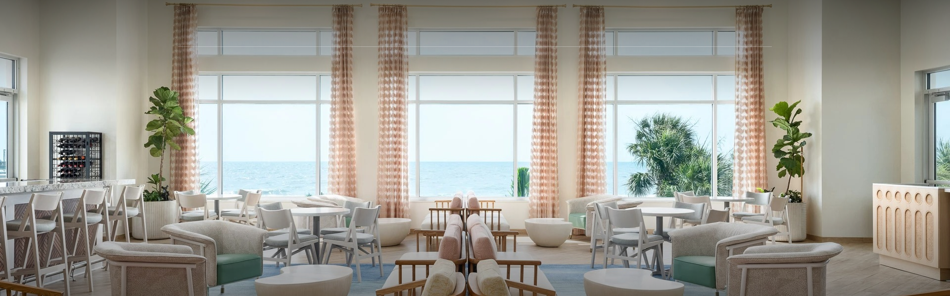 a room with chairs and tables and a view of the ocean