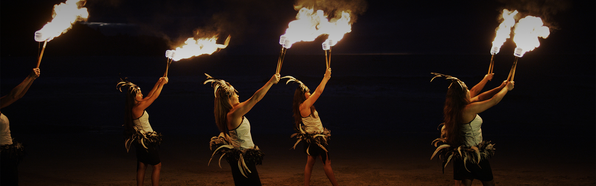 two women holding torches with flames