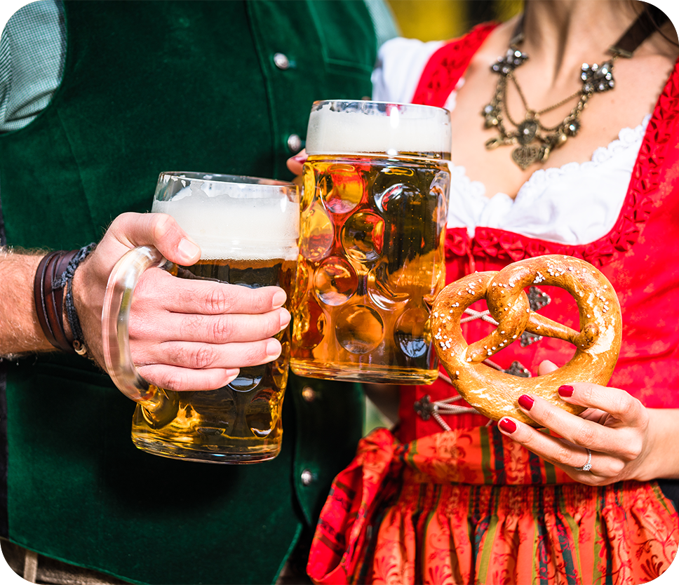 a man and woman holding beer glasses and pretzel