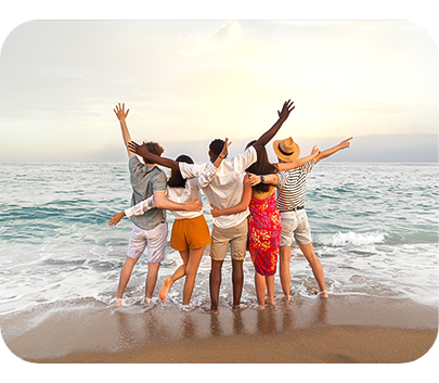 a group of people standing on a beach with arms raised