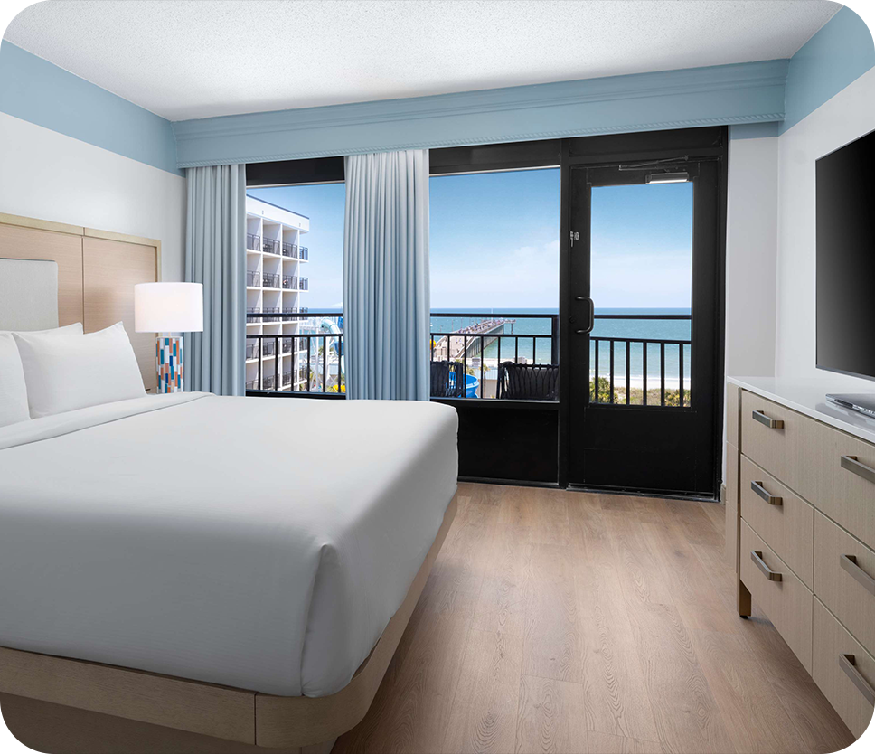 a hotel room with a large bed and a glass door