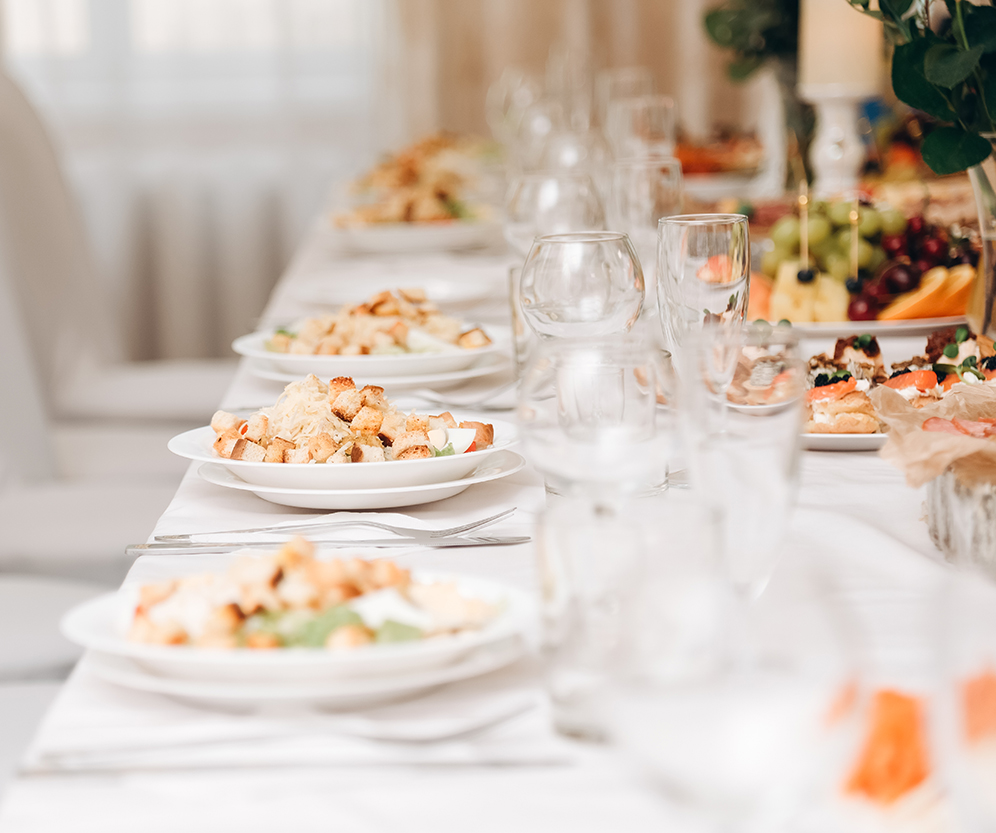 a table with plates of food and glasses