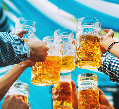a group of people holding up glasses of beer