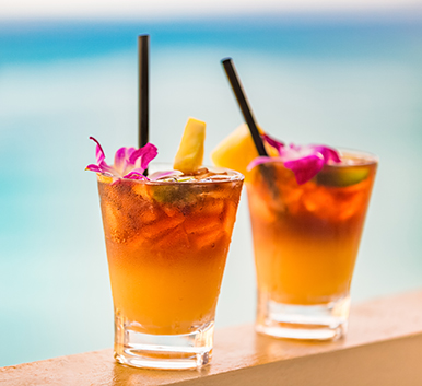two glasses of drinks with flowers and straws